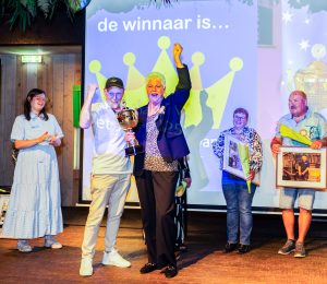 Jan Harkema, de SVP-collega die vorig jaar de titel Schoonmaker van het jaar won, overhandigt de beker aan de kersverse winnaar.